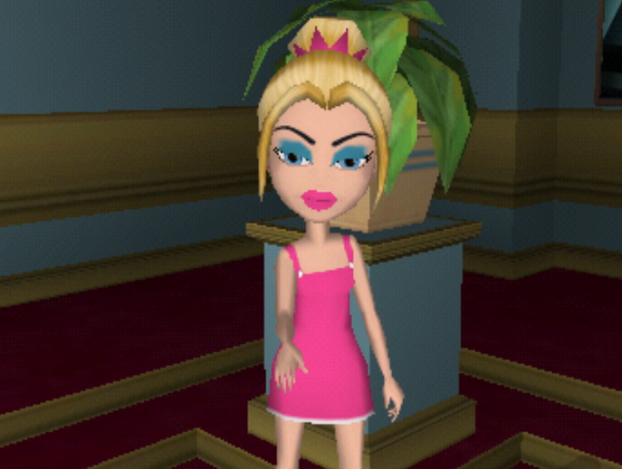 Kirstee is a white blonde woman with messy blue eyeshadow. She wears a pink dress and lipstick. Her hair is in a bun with a small pink tiara around it. Her eyes are blue.